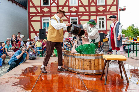 Traditionelle Wassertaufe auf dem Marktplatz des Freilichtmuseums. Foto: Harald Kalbhenn