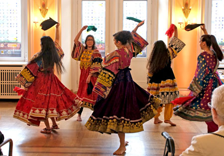 Kulturell umrahmt wurde die Veranstaltung von  Tänzerinnen der afghanischen Frauentanzgruppe "Atan" in traditionellen Kostümen, die seit der Machtübernahme der Taliban in Afghanistan nicht mehr öffentlich getragen werden dürfen. Hier nur von hinten u. mit unkenntlichem Gesicht. © Foto Diether von Goddenthow