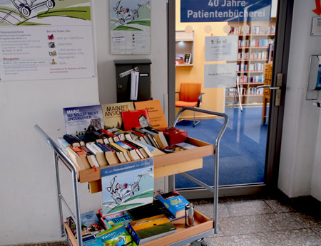 Einer der typischen Bibliothekswagen, mit denen die ehrenamtlichen Mitarbeiter Patienten in Zimmern auf 40 Stationen der Unimedizin Mainz aufsuchen. © Foto Diether von Goddenthow